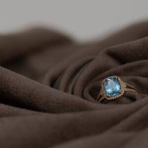 Close-up of a luxurious aquamarine ring set against rich brown fabric, perfect for elegance and style.